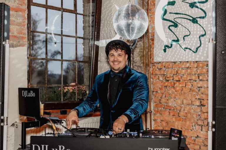 Ein DJ im blauen Anzug am Mischpult