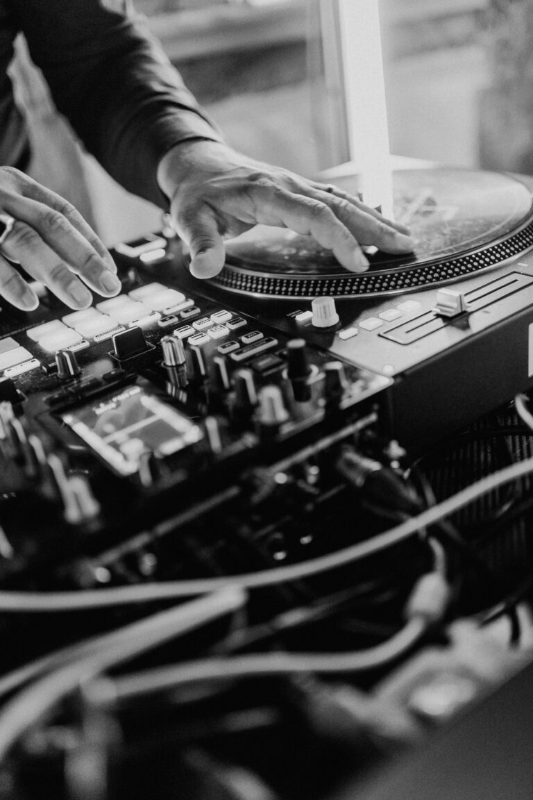 Ein DJ Mischpult, auf dem eine Hand auf einer Platte dreht
